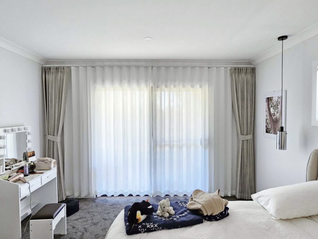 Natural beige pinch pleat curtains paired with S-fold privacy sheers.