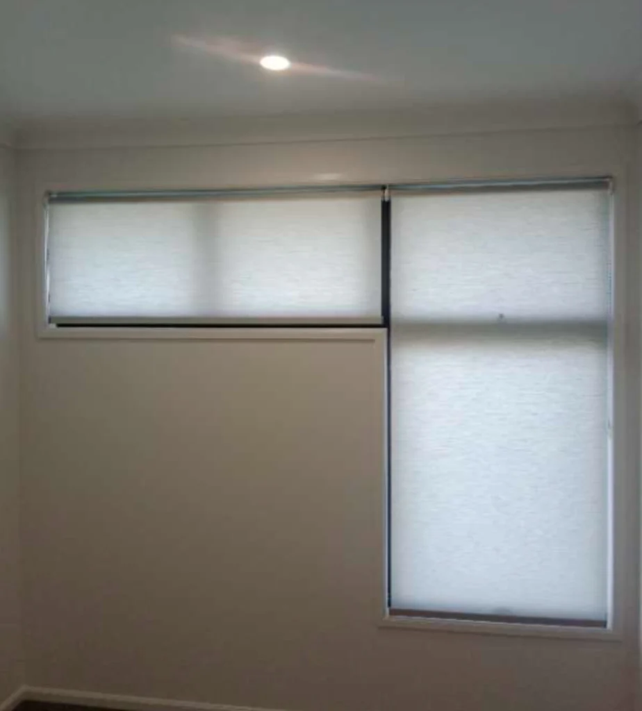 2 white light filtering privacy roller blinds for two different feature windows