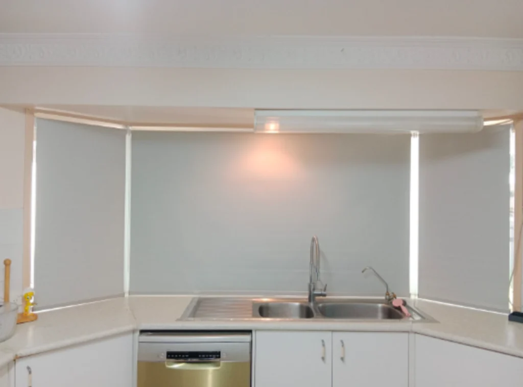 3 white blockout roller blinds installed on the kitchen bay windows