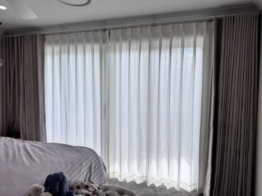 grey s fold blockout curtain and pinch privacy sheer installed in the bedroom