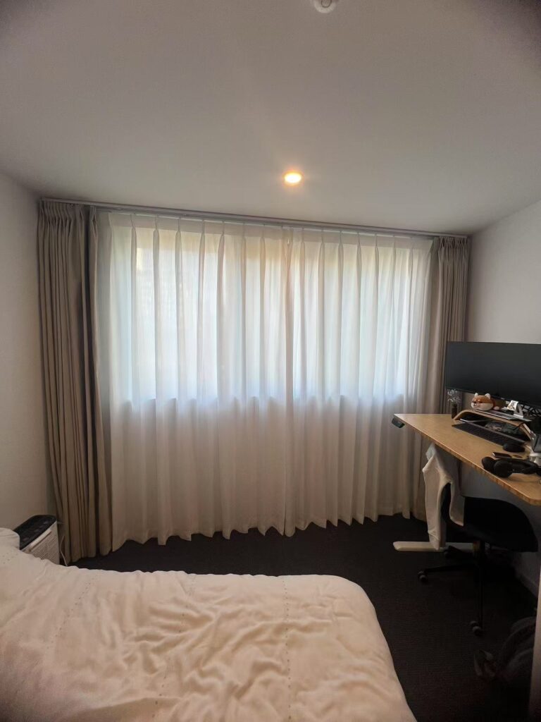 installed brown pinch blockout curtain and pinch privacy sheer for one wondow in the bedroom