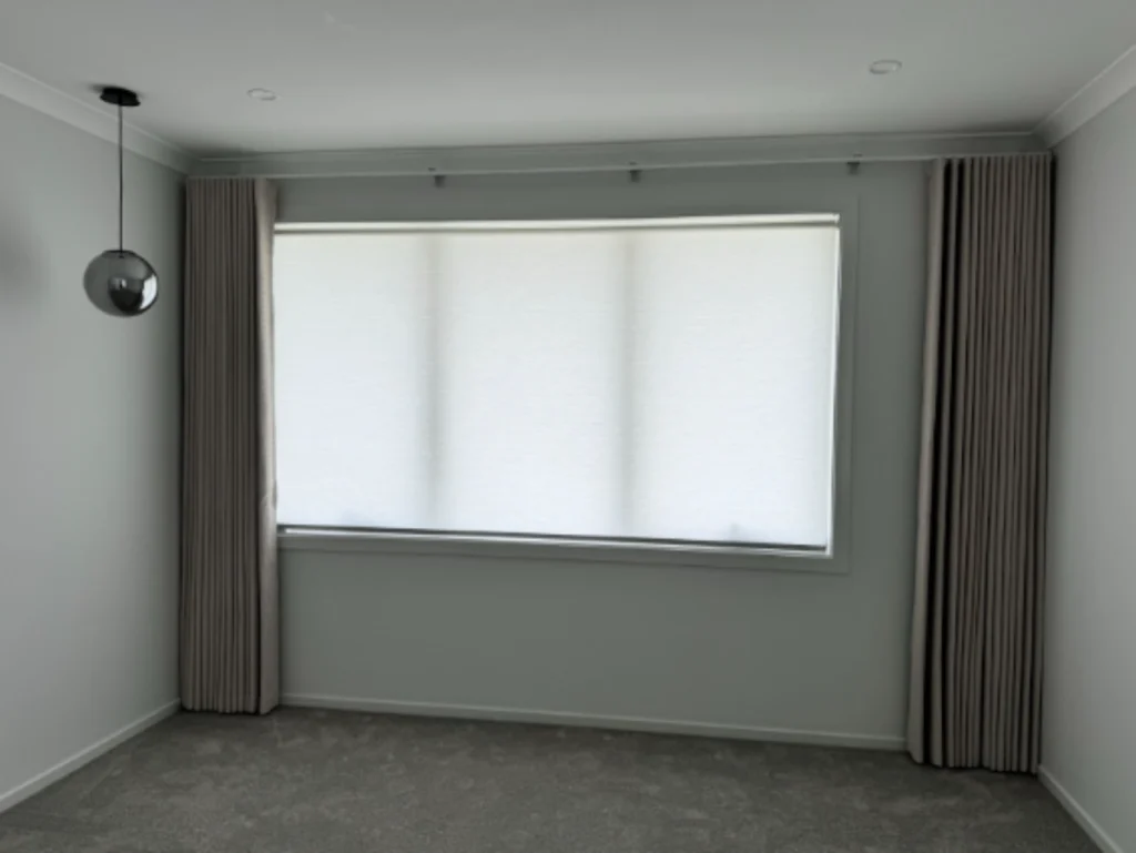 s fold blockout curtain and white light filtering privacy roller blind installed for one window