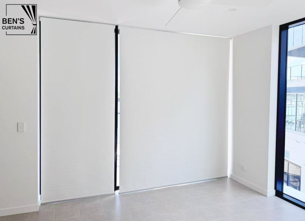 white blockout roller blinds installed on three panel sliding doors