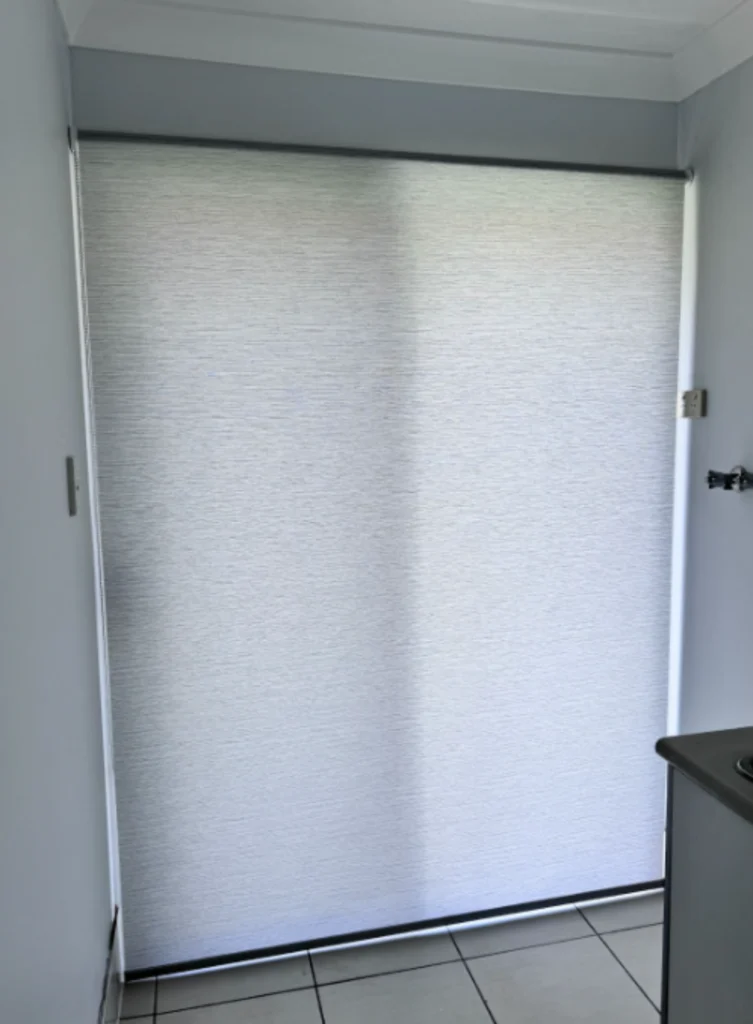 white light filtering privacy roller blind installed on sliding door of laundry