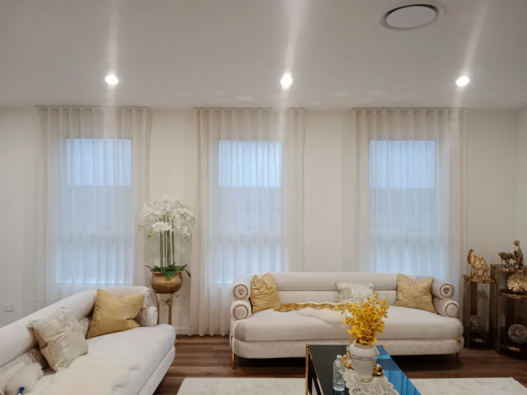 s fold transparent sheers installed for three windows in living are