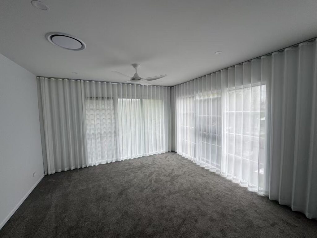 s fold transparent sheers installed for two windows in bedroom