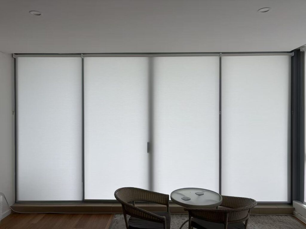 three white light filtering privacy roller blinds installed for one window in dining area